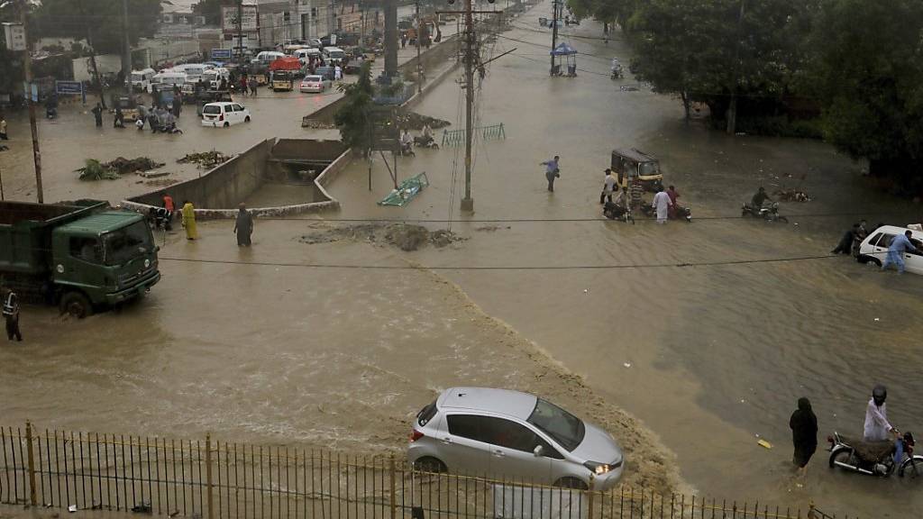 Eine überschwemmte Straße in der pakistanischen Hafenstadt Karatschi. Foto: Fareed Khan/AP/dpa