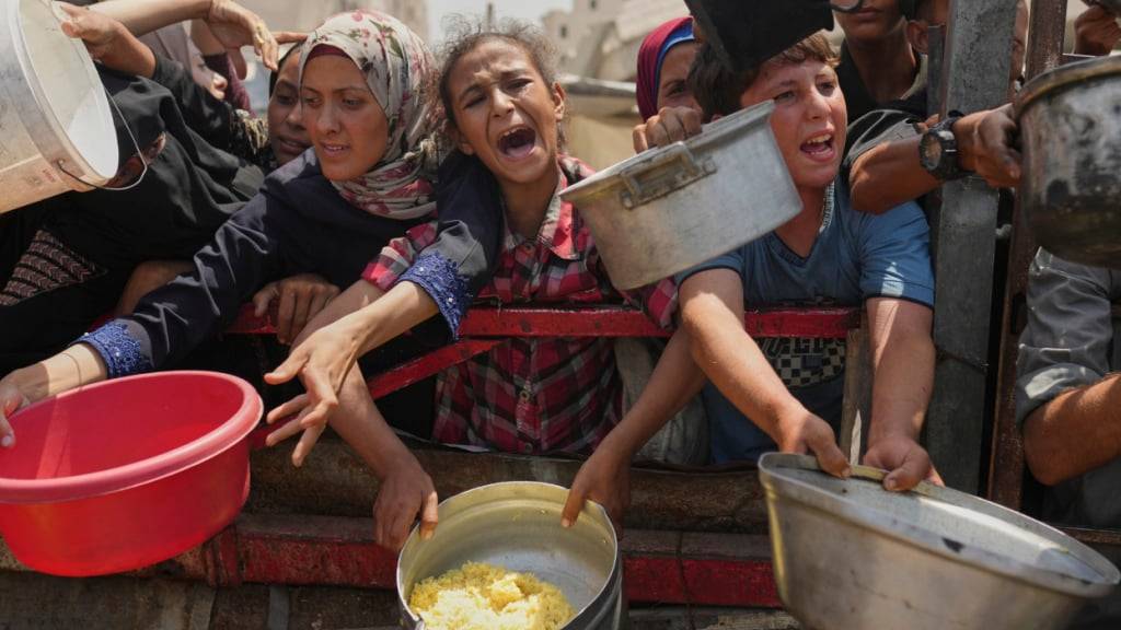 Palästinenser kämpfen um gespendete Lebensmittel in einer Gemeinschaftsküche im nördlichen Gazastreifen. Foto: Jehad Alshrafi/AP/dpa