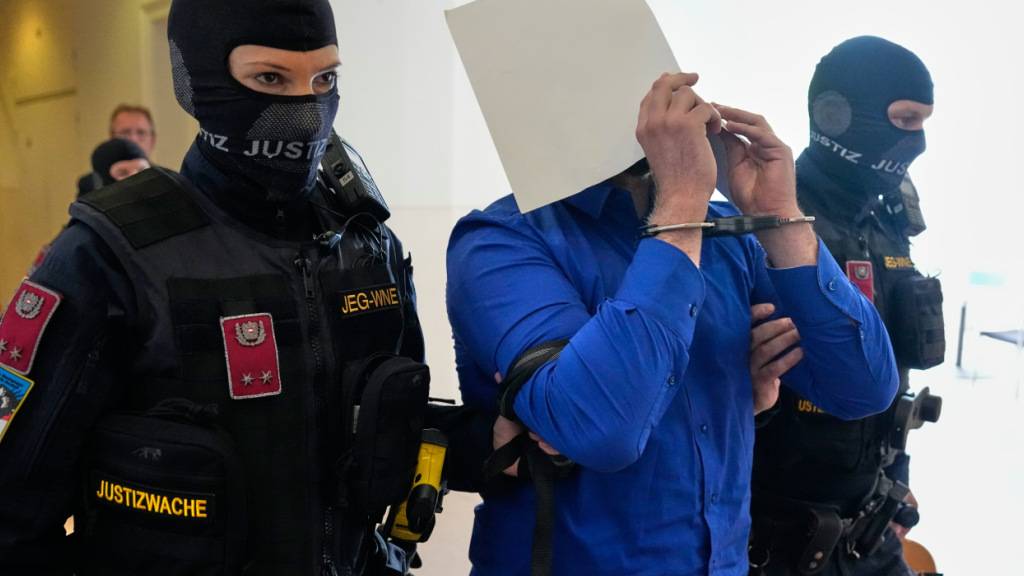 ARCHIV - Der Angeklagte verbirgt sein Gesicht hinter Aktenordnern, als er aus dem Gerichtssaal geführt wird. Foto: Matthias Schrader/AP/dpa