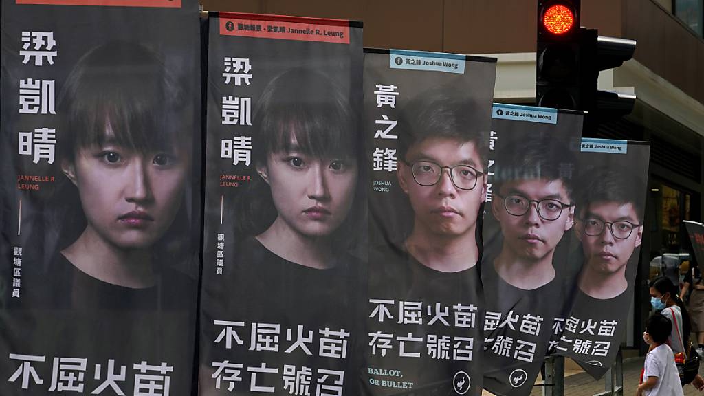 ARCHIV - Banner des prodemokratischen Kandidaten Joshua Wong sind vor einer U-Bahn-Station zu sehen. Rund 50 prodemokratische Aktivisten und frühere Abgeordnete sind in Hongkong wegen angeblicher Verstöße gegen das neue Sicherheitsgesetz festgenommen worden. Foto: Kin Cheung/AP/dpa