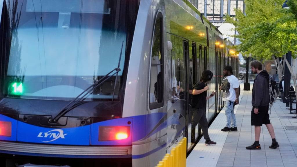 Menschen steigen in eine Stadtbahn des Charlotte Area Transit Systems ein und aus. Foto: Erik Verduzco/AP/dpa
