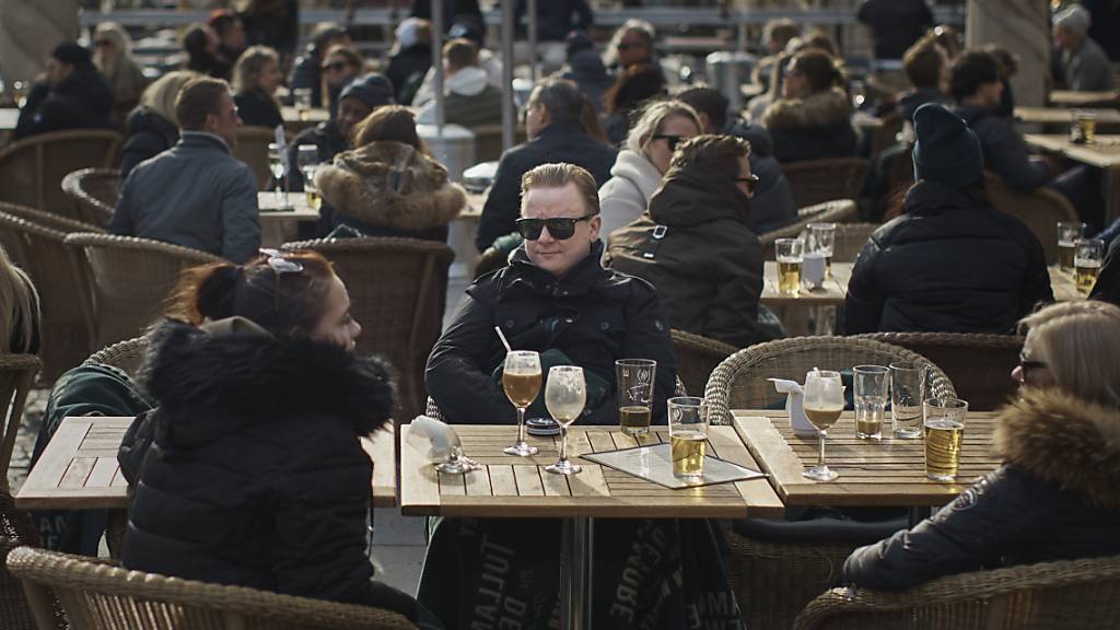ARCHIV - Menschen sitzen vor einem Restaurant am Bürgerplatz in Stockholm. Foto: Andres Kudacki/AP/dpa