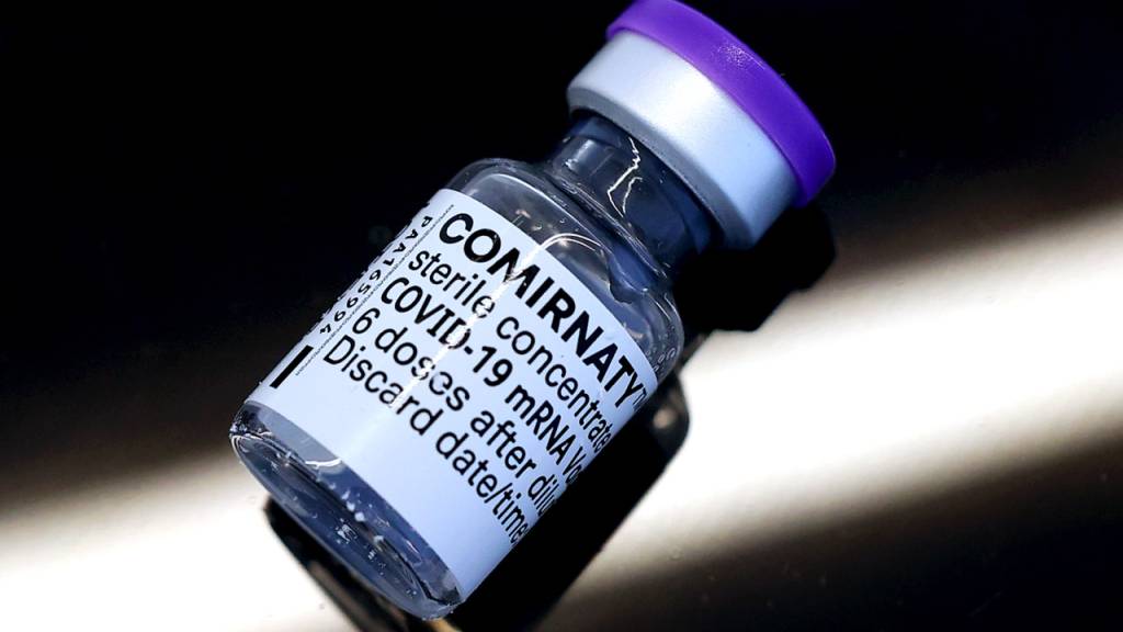 ARCHIV - Eine Ampulle mit dem Corona-Impfstoff Comirnaty der Hersteller Biontech und Pfizer liegt auf einem Tisch. Foto: Ronny Hartmann/dpa