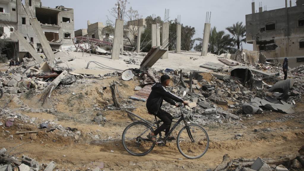 Palästinenser inspizieren die Ruinen eines Wohnhauses nach einem israelischen Luftangriff. Foto: Hatem Ali/AP/dpa