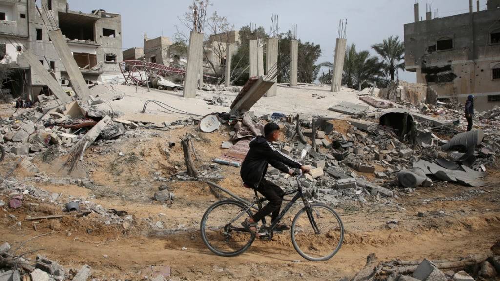 Palästinenser inspizieren die Ruinen eines Wohnhauses nach einem israelischen Luftangriff. Foto: Hatem Ali/AP/dpa