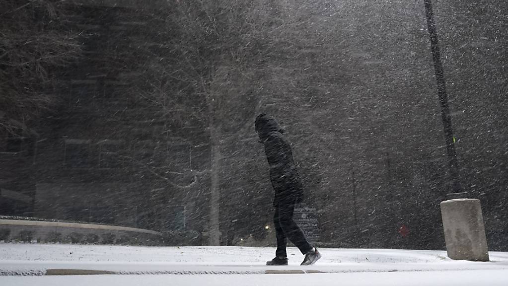 Eine Frau geht durch fallenden Schnee. Im südlichen US-Bundesstaat Texas sind wegen ungewöhnlich kalten Winterwetters Hunderttausende Menschen mindestens zeitweise ohne Strom gewesen. Foto: Eric Gay/AP/dpa
