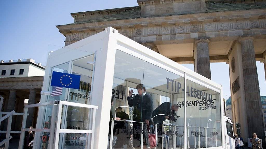 Geheime Dokumente im Glaskasten: Greenpeace macht hinter verschlossenen Türen verhandelte TTIP-Unterlagen der Öffentlichkeit zugänglich. Hier in Berlin im Glaskasten vor dem Brandenburger Tor.