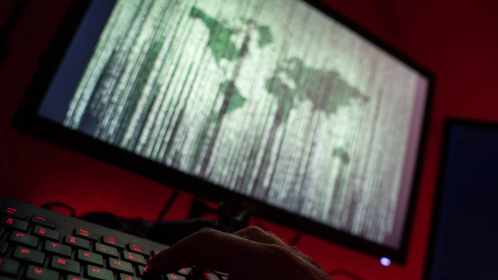 ILLUSTRATION - Ein Mann sitzt am Rechner und tippt auf einer Tastatur. Foto: Nicolas Armer/dpa