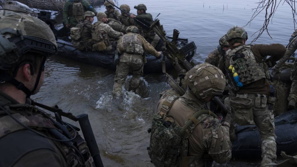 Ukrainische Soldaten steigen in ein Boot am Ufer des Flusses Dnipro an der Frontlinie nahe Cherson. Foto: Mstyslav Chernov/AP/dpa