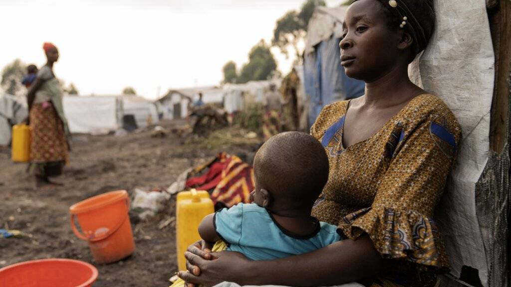 ARCHIV - Eine Mutter mit ihrem Kind sitzt vor ihrem Zelt in einem Flüchtlingslager im Kongo. Foto: Moses Sawasawa/AP/dpa/Symbolbild