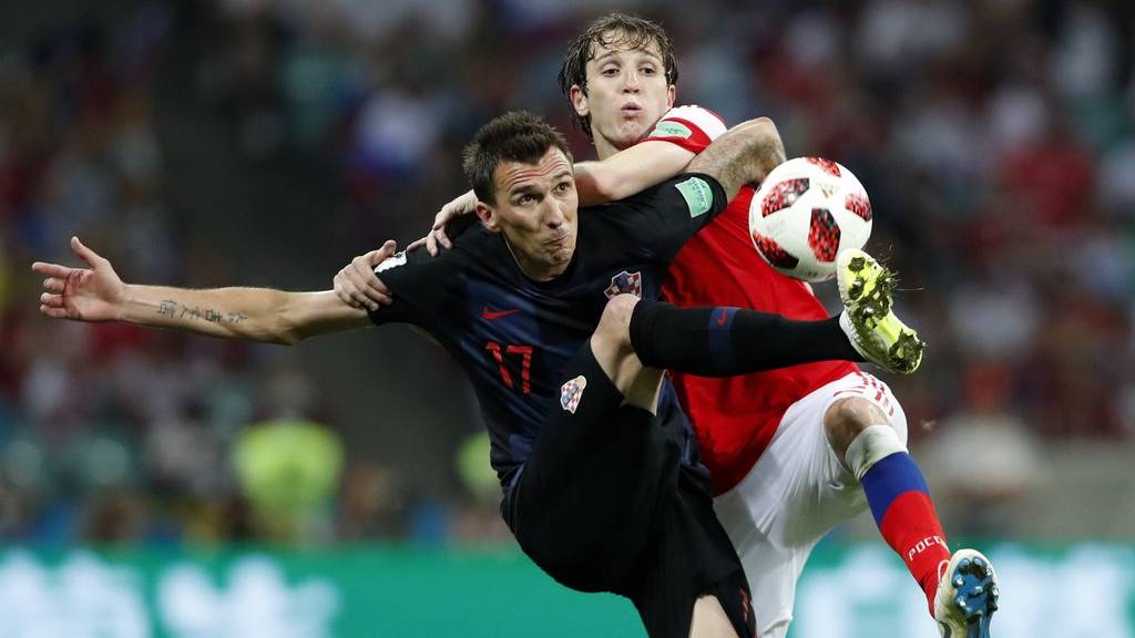 Croatia's Mario Mandzukic, left, challenges for the ball with Russia's Mario Fernandes during the quarterfinal match between Russia and Croatia at the 2018 soccer World Cup in the Fisht Stadium, in Sochi, Russia, Saturday, July 7, 2018. (AP Photo/Rebecca Blackwell)