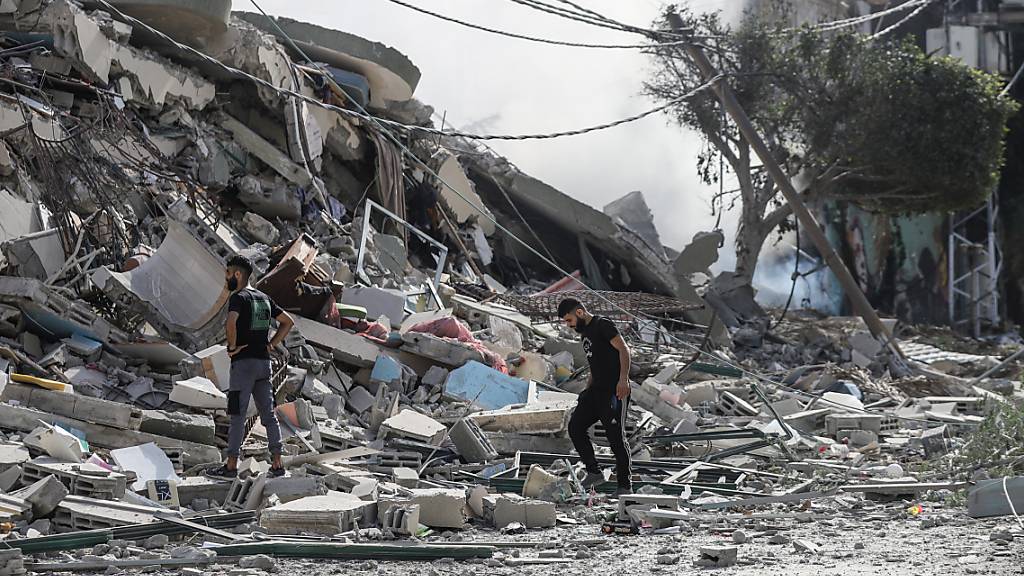 Palästinenser inspizieren die Trümmer nach einem israelischen Angriff auf das Viertel Tel al-Hawa. Foto: Mohammad Abu Elsebah/dpa
