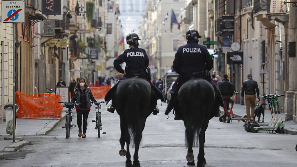 Polizisten auf Pferden patrouillieren auf der Einkaufsstraße Via del Corso im Stadtzentrum von Rom. Foto: Gregorio Borgia/AP/dpa