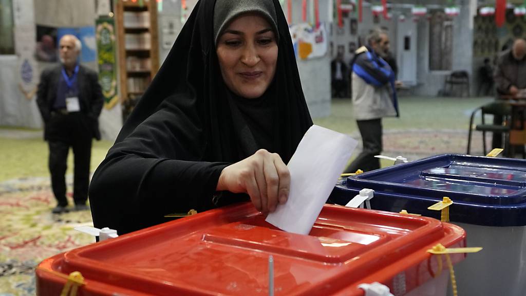 Eine Frau gibt während der Parlamentswahlen und der Wahlen zur Expertenversammlung in einem Wahllokal ihren Stimmzettel ab. Foto: Vahid Salemi/AP