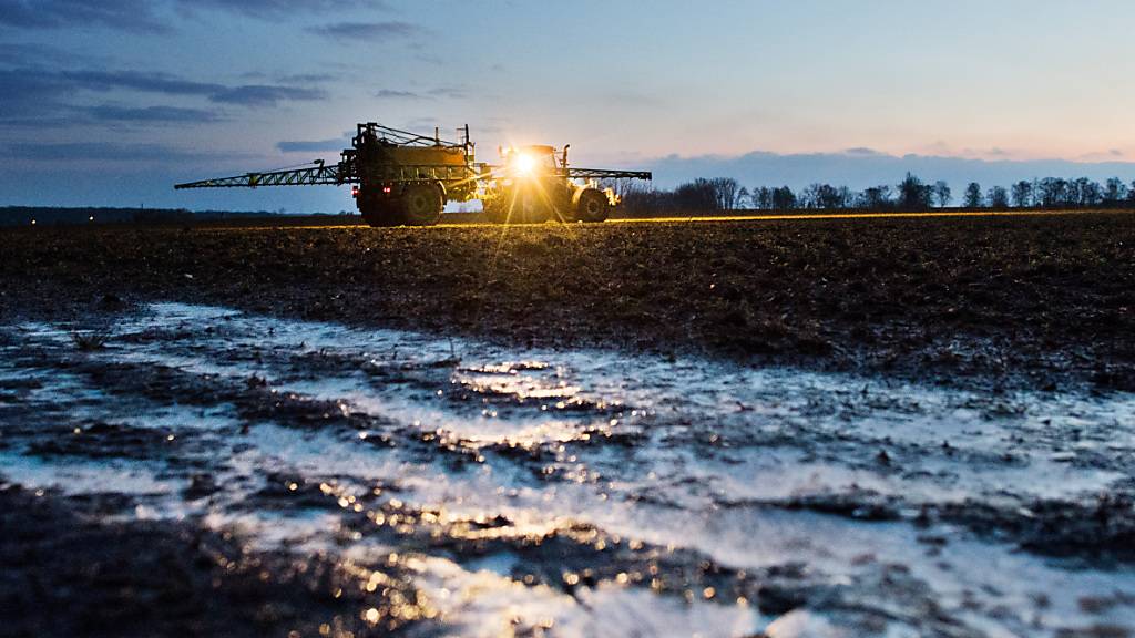 Ein Landwirt düngt in der Morgendämmerung bei Temperaturen um den Gefrierpunkt ein Feld mit Stickstoffdünger. (Archivbild)