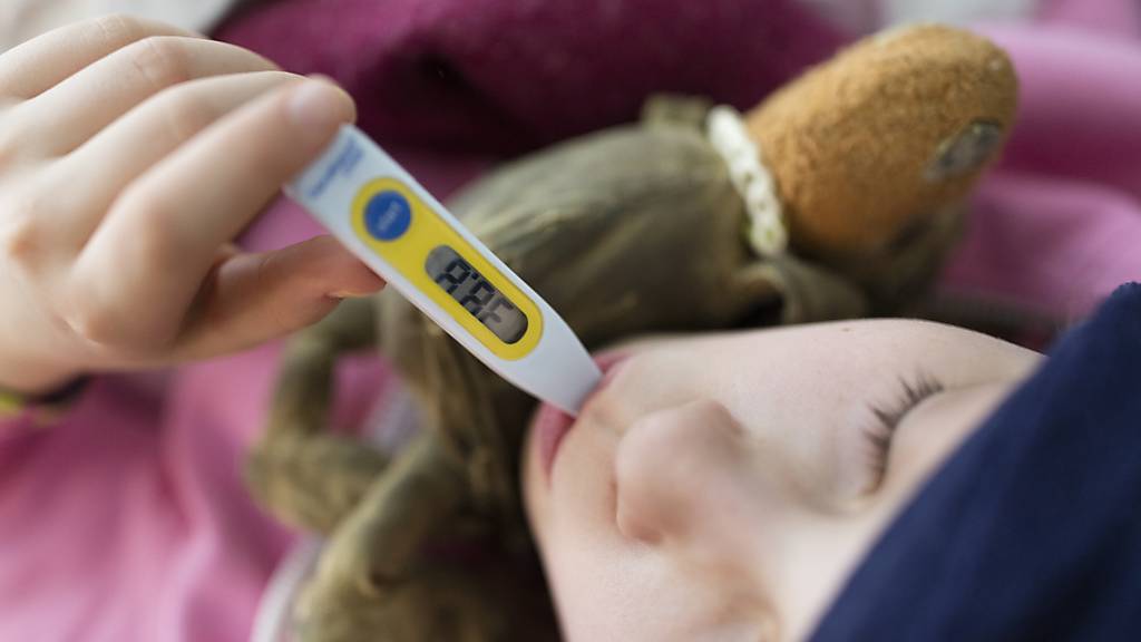 Ein Mädchen misst seine Körpertemperatur: Anhaltendes Fieber gehört zu den Symptomen des pädiatrischen entzündlichen Multisystem-Syndroms. (Symbolbild)