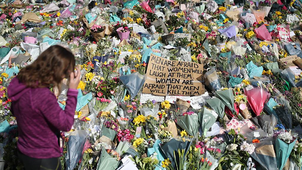 ARCHIV - Eine Frau schaut sich die Blumen an, die für die getötete Sarah Everard im Clapham Common Park niedergelegt wurden. (Archivbild) Foto: Yui Mok/PA Wire/dpa