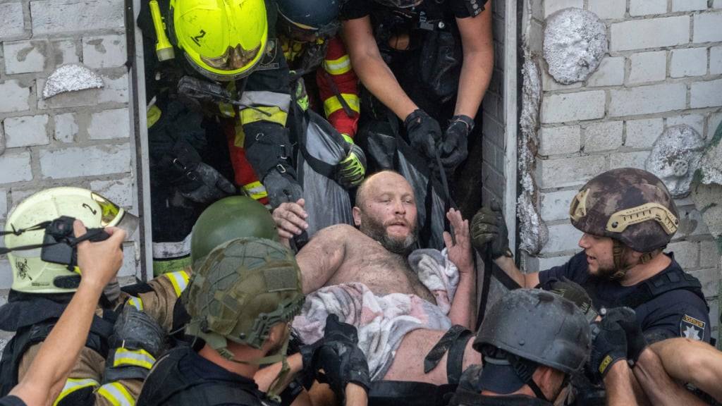 dpatopbilder - Rettungskräfte evakuieren einen verletzten Zivilisten, nachdem ein Wohnhaus bei einem russischen Raketenangriff in Charkiw am Montag getroffen wurde. Foto: Andrii Marienko/AP/dpa
