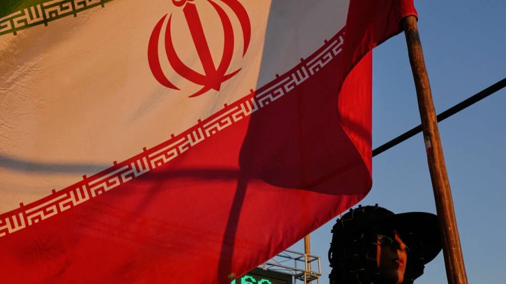 ARCHIV - Eine junge Frau hält im Rahmen einer regierungsfreundlichen Kundgebung in Teheran eine iranische Flagge in der Hand. Foto: Vahid Salemi/AP/dpa/Symbolbild