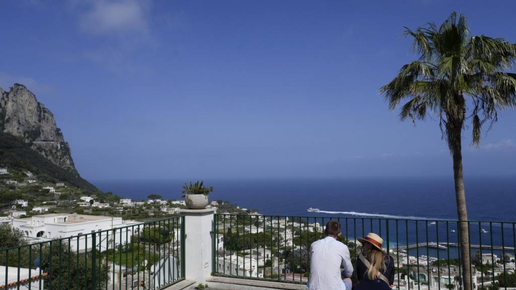 ARCHIV - Touristen blicken auf die Häuser von Capri. Foto: Gregorio Borgia/AP/dpa