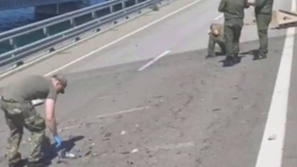 HANDOUT - Ermittler arbeiten an einer beschädigten Teil einer Automobilverbindung der Krim-Brücke Anfang des Monats. Foto: -/Investigative Committee of Russia/AP/dpa - ACHTUNG: Nur zur redaktionellen Verwendung und nur mit vollständiger Nennung des vorstehenden Credits