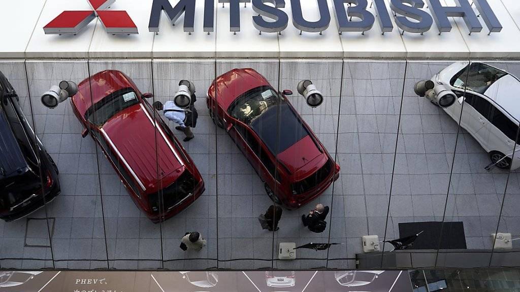 Seit 25 Jahren hat Mitsubishi bei Spritverbrauchstests getrickst. Autos spiegeln sich in der Zentrale des Autoherstellers in Tokio.