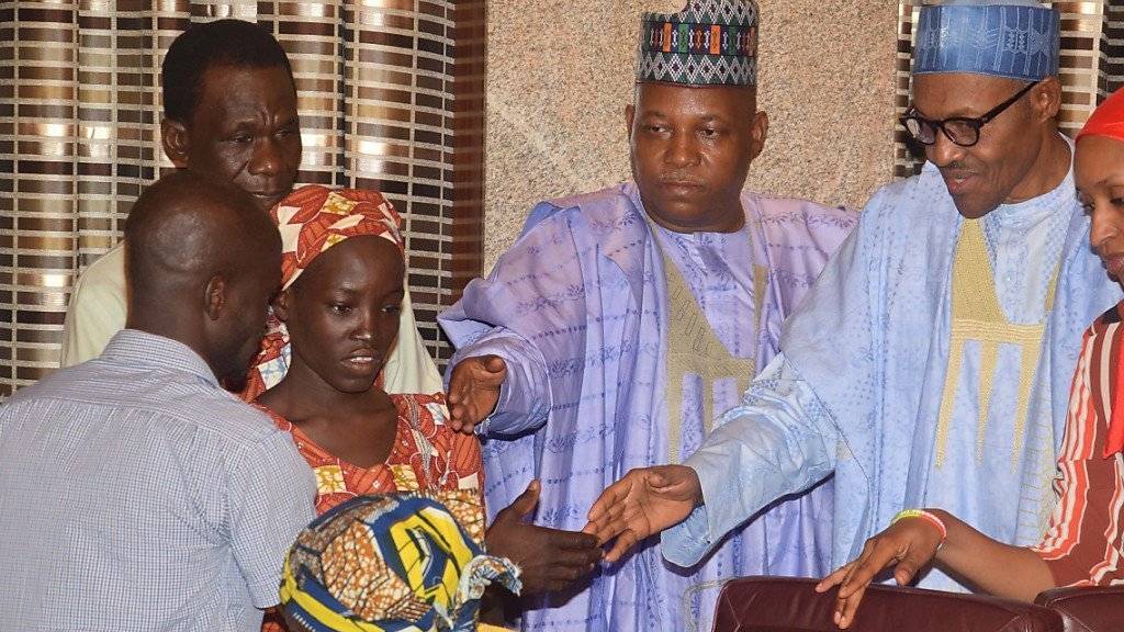 Das erste von Boko Haram entführte Mädchen (links), das freigekommen ist, wird vom nigerianischen Präsidenten Buhari (rechts) empfangen. Ein zweites Mädchen soll mittlerweile gefunden worden sein.
