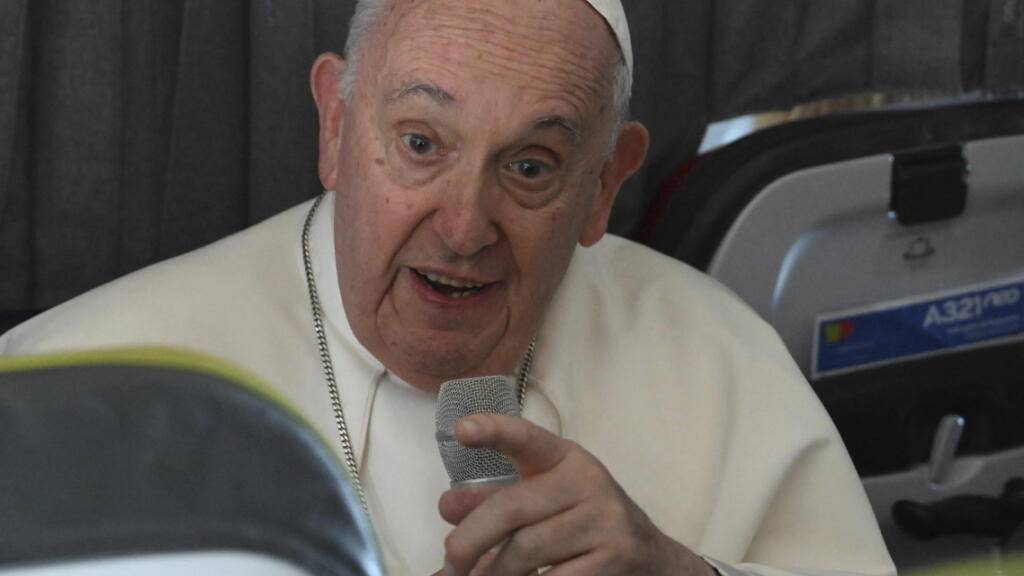 Papst Franziskus spricht an Bord des Flugzeugs auf dem Weg nach Rom mit Journalisten. Foto: Maurizio Brambatti/ANSA/AP/dpa
