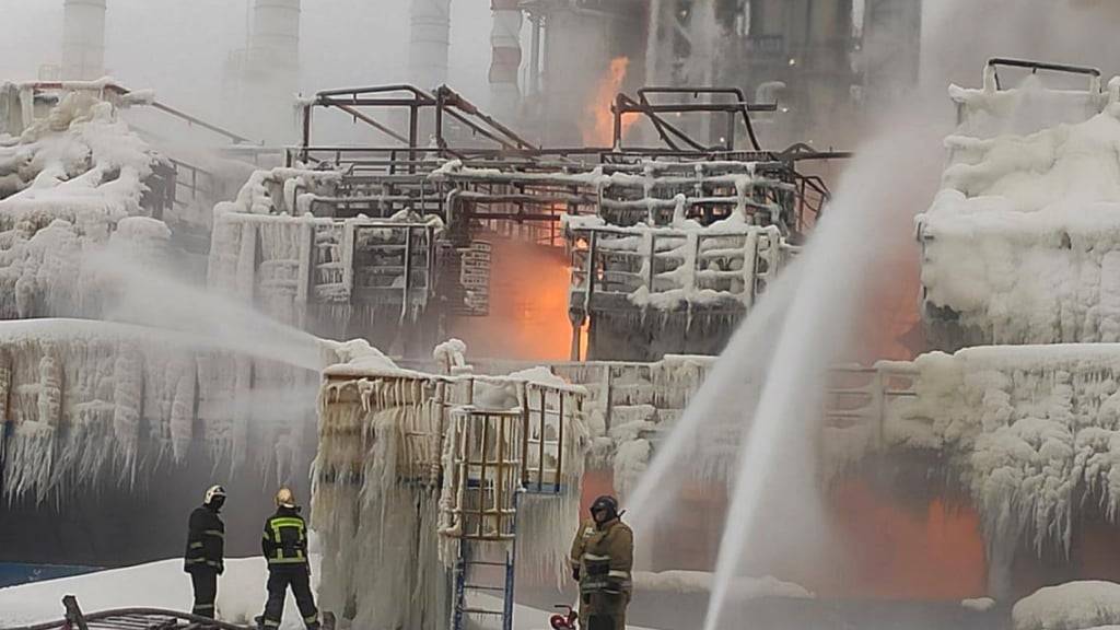 HANDOUT - Feuerwehrleute einen Brand bei Russlands zweitgrößtem Erdgasproduzenten Novatek. Foto: Uncredited/Telegram Channel of head of the Kingisepp district administration Yuri Zapalatskiy/AP/dpa - ACHTUNG: Nur zur redaktionellen Verwendung und nur mit vollständiger Nennung des vorstehenden Credits