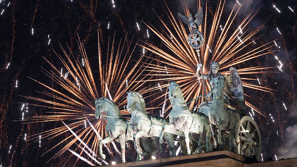 dpatopbilder - Feuerwerk zum Jahreswechsel steigt hinter dem Brandenburger Tor auf. Foto: Sebastian Christoph Gollnow/dpa