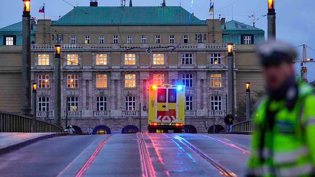 Ein Krankenwagen fährt in Richtung des Gebäudes der Philosophischen Fakultät der Karlsuniversität. An einer Hochschule in der Prager Innenstadt sollen Schüsse gefallen sein. Foto: Petr David Josek/AP