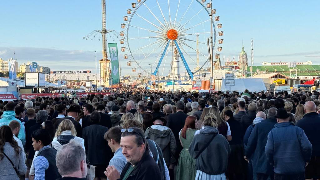 Zahlreiche Besucher betreten nach dem Einlass das Gelände des Oktoberfests. Foto: Christof Rührmair/dpa