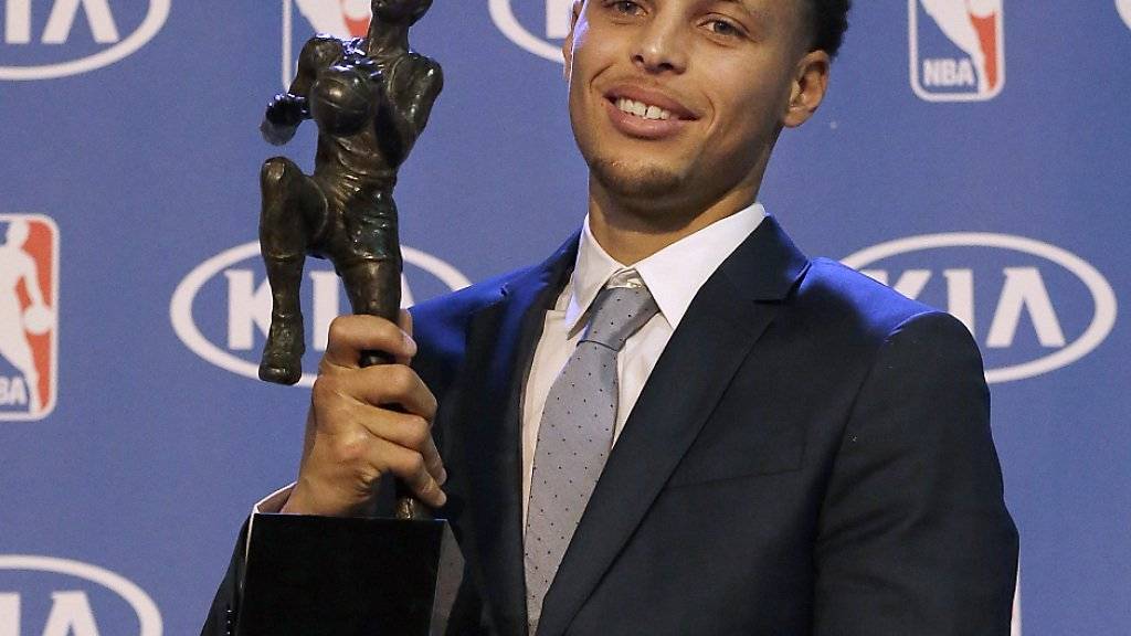 Stephen Curry hält stolz die MVP-Trophäe in der Hand