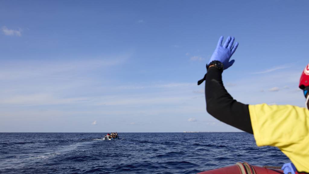 Ein Schnellboot der NGO Open Arms nähert sich einem kleinen Fischerboot, auf dem Migranten unterwegs sind.