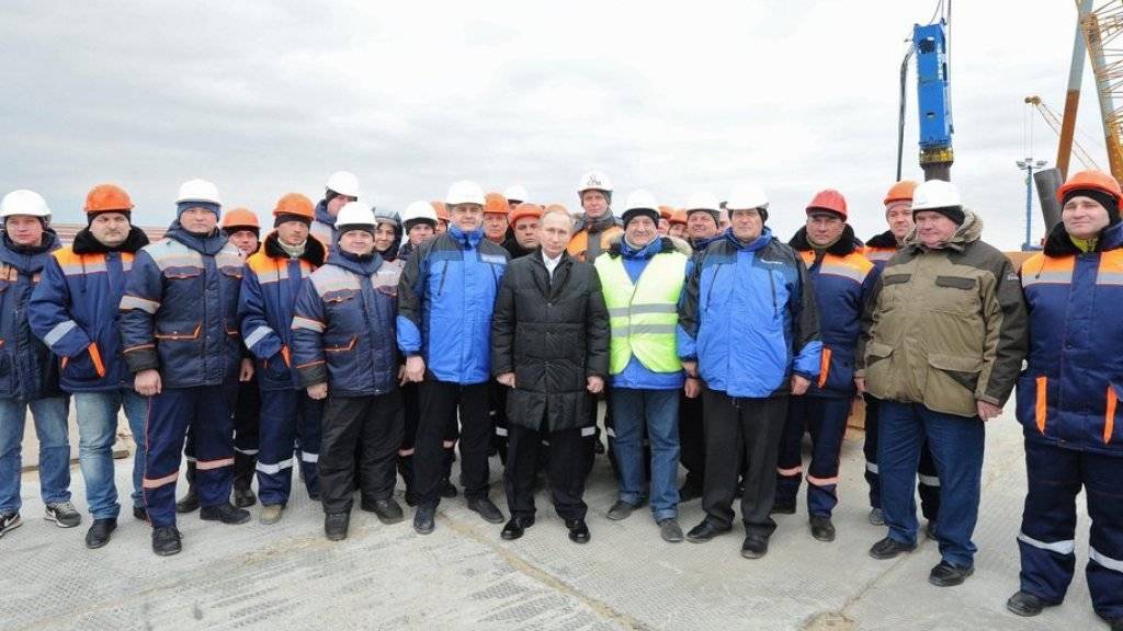 Wladimir Putin (Mitte) posiert am Freitag mit Arbeitern auf der Baustelle der ersten dauerhaften Brücke über die Meerenge von Kertsch.