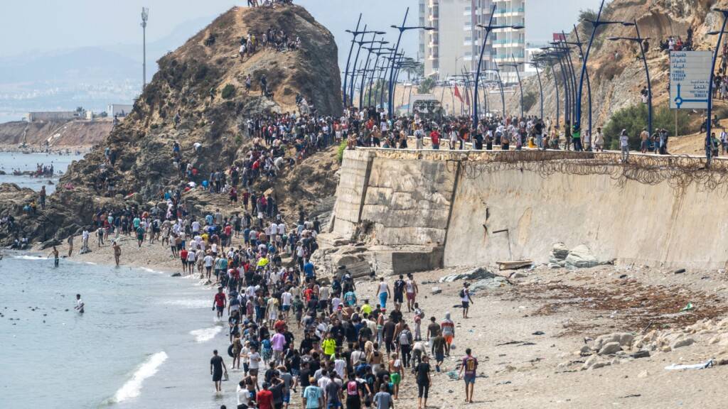 Menschen laufen am Strand entlang, nachdem sie versucht hatten, von der marokkanischen Stadt Fnideq im Norden in die spanische Exklave Ceuta zu gelangen. Foto: STR/AP/dpa