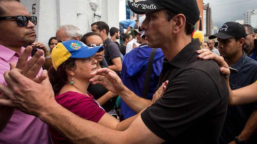 Oppositionsführer Henrique Capriles grüsst Anhänger während eines Protests in Caracas (Archiv)