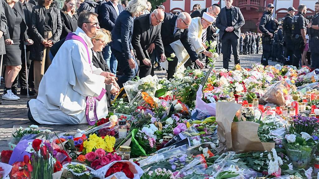 Bei einer Kundgebung unter dem Motto «Mannheim hält zusammen», die anlässlich einer Messerattacke stattfindet, bei der ein Polizist getötet wurde, legen Geistliche verschiedener Konfessionen Blumen nieder. Foto: Uli Deck/dpa