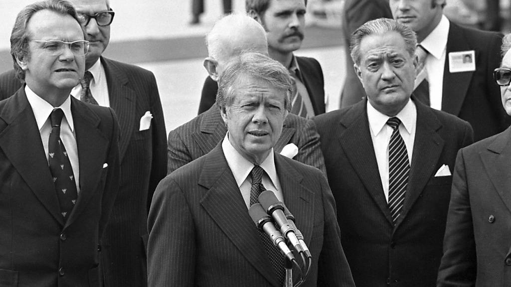 Jimmy Carter, Mitte, und sein Aussenminister Cyrus Vance, Mitte rechts, wurden am 9. Mai 1977 am Flughafen von Genf-Cointrin empfangen. Carter war in Genf, um mit dem syrischen Ministerpraesidenten Hafiz al-Assad zu Friedensverhandlungen im Nahostkonflikt zusammentreffen.