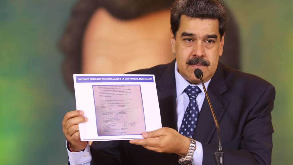 HANDOUT - Auf diesem vom venezolanischen Präsidentenamt zur Verfügung gestellten Bild zeigt Nicolas Maduro, Präsident von Venezuela, die Kopie eines Dokumentes, das beweisen soll, dass der Oppositionsführer Guaido einen angeblichen Invasionsversuch mit «terroristischen Söldnern» unterstützt haben soll. Die Regierung von Maduro versichert, «Söldner» hätten das Land angegriffen. Hinter dem Plan steckten Kolumbien und die USA. Das Präsidentenamt veröffentlichte ein Video, in dem ein festgenommener US-Bürger Details seiner Mitarbeit schildert. Foto: Marcelo Garcia/Prensa Miraflores/dpa - ACHTUNG: Nur zur redaktionellen Verwendung im Zusammenhang mit der aktuellen Berichterstattung und nur mit vollständiger Nennung des vorstehenden Credits