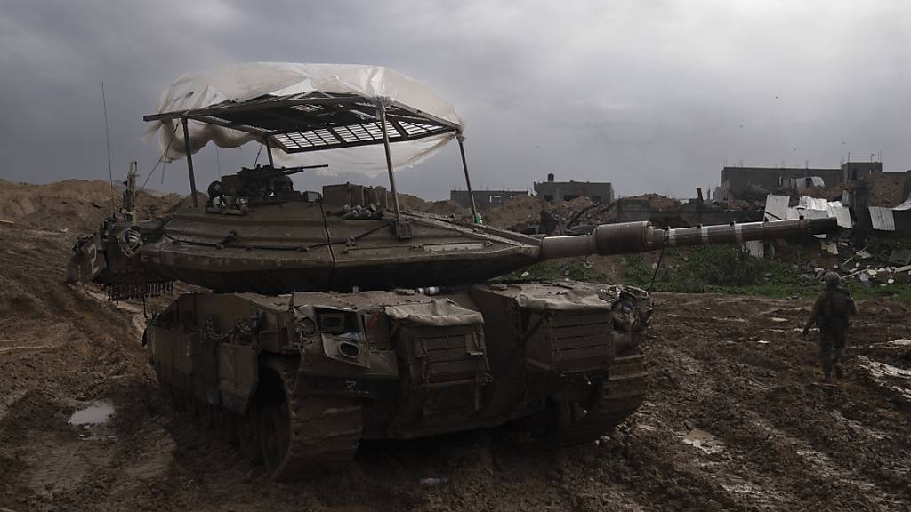 ARCHIV - Israelische Soldaten gehen während der Bodenoffensive im Gazastreifen an einem Panzer vorbei. Foto: Sam McNeil/AP/dpa