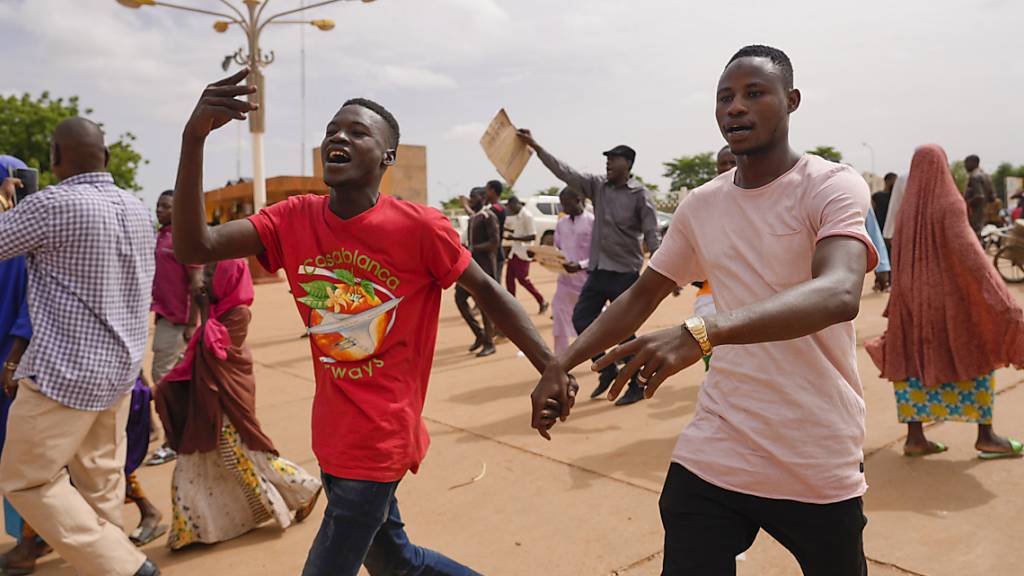 Anhänger der regierenden Junta von Niger jubeln. Foto: Sam Mednick/AP/dpa