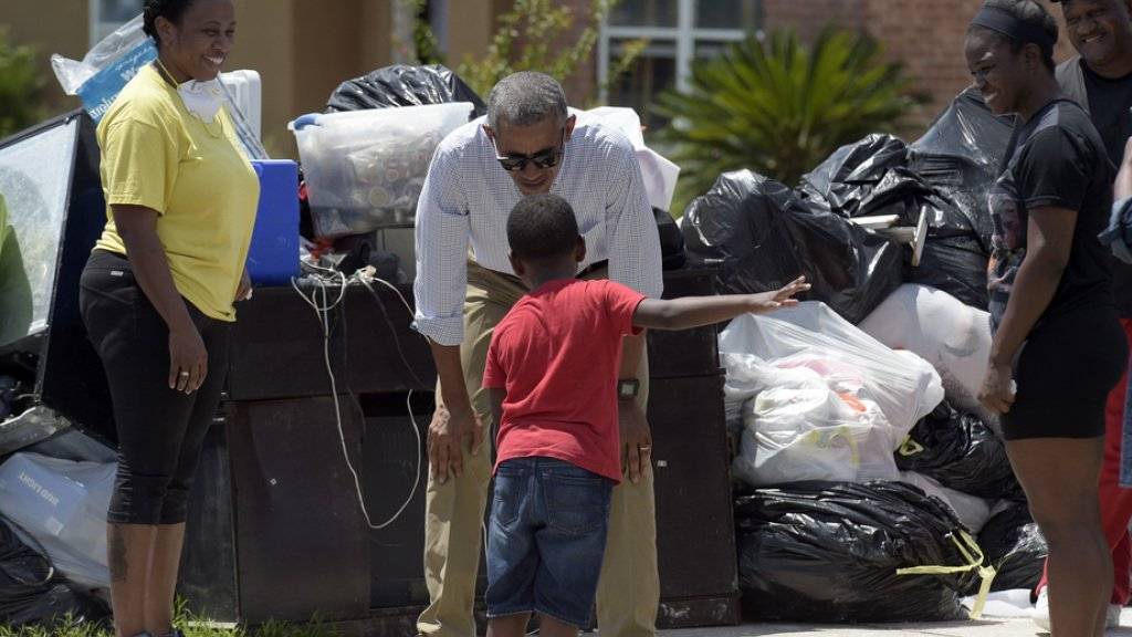US-Präsident Barack Obama macht den Betroffenen der Überschwemmungen im US-Bundesstaat Louisiana Mut. Bei seinem Rundgang in Baton Rouge spricht er mit einem Knaben.