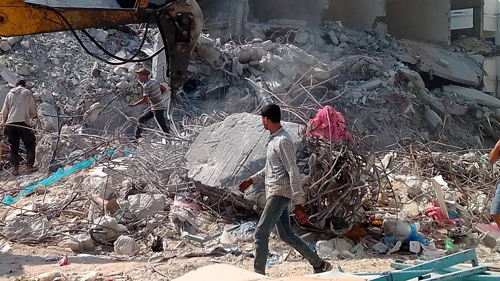 Palästinensische Männer arbeiten auf einem Grundstück in Gaza-Stadt, um Folgen der Zerstörungen durch Luftangriffe während des Konflikts im Mai zu beseitigen. 100 Tage nach der Waffenruhe zwischen Israel und der in Gaza herrschenden Hamas steht der Wiederaufbau noch am Anfang. Foto: Eva-Maria Krafczyk/dpa