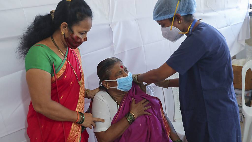Eine Frau erhält von einer medizinischen Mitarbeiterin eine Corona-Schutzimpfung mit dem AstraZeneca-Impfstoff, der in Indien unter dem Namen Covishield vertrieben wird. Foto: Rafiq Maqbool/AP/dpa