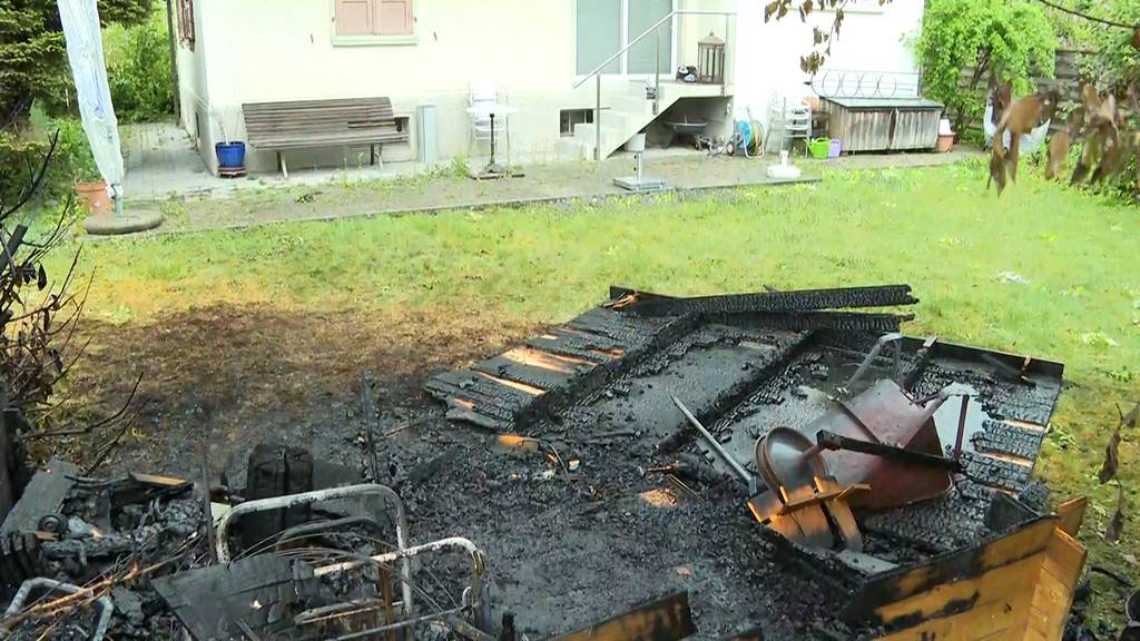 Anwohner löschen Feuer mit Schlauch