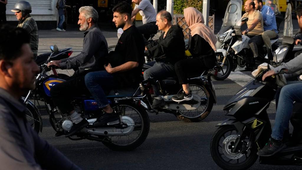 ARCHIV - Menschen fahren auf einer Straße in der Innenstadt von Teheran. Foto: Vahid Salemi/AP/dpa/Archivbild