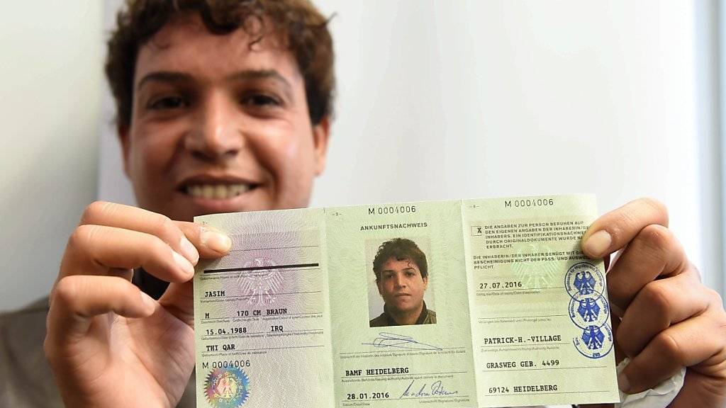 Der irakische Flüchtling Jasmin Abed zeigt seinen Flüchtlingsausweis, den er in Heidelberg erhalten hat.