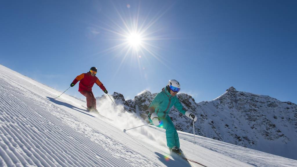 Skifahren auf der Skipiste mit Sonne (Symbolbild)