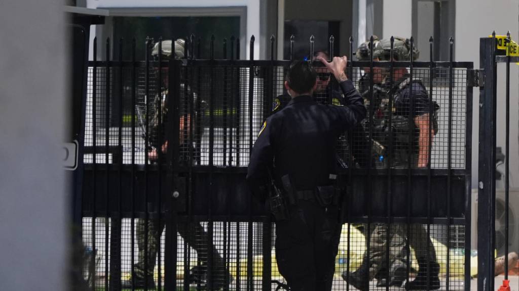 Einsatzkräfte gehen an einem mit Plane abgedeckten Opfer vorbei am Tatort nach Schüssen vor dem Islamic Center of San Diego. Foto: Gregory Bull/AP/dpa